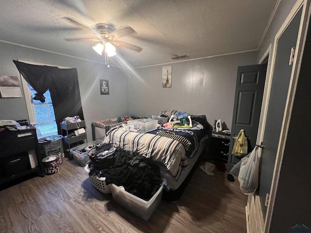 bedroom with crown molding, hardwood / wood-style flooring, a textured ceiling, and ceiling fan