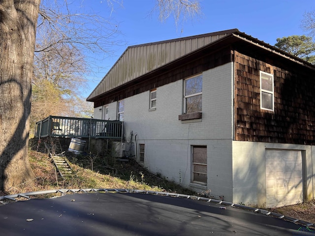 view of side of home featuring a garage and a deck