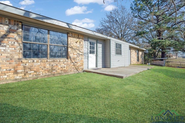 rear view of property with a patio and a lawn