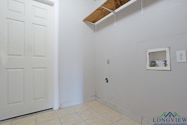 clothes washing area featuring light tile patterned flooring and washer hookup