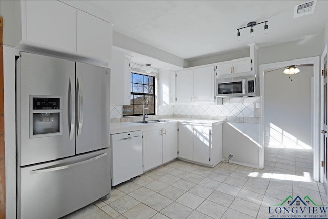 kitchen with sink, light tile patterned floors, white cabinetry, stainless steel appliances, and tasteful backsplash