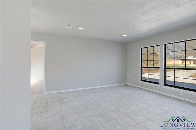 unfurnished room with a textured ceiling