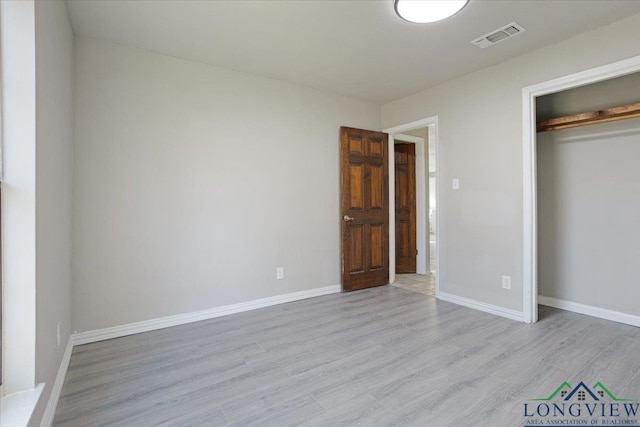 unfurnished bedroom with light hardwood / wood-style floors and a closet