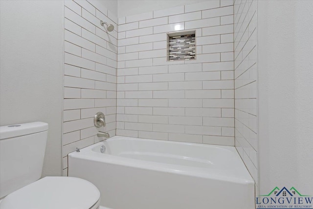 bathroom featuring toilet and tiled shower / bath