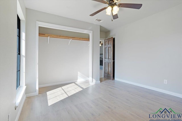 unfurnished bedroom featuring ceiling fan, light hardwood / wood-style floors, and a closet