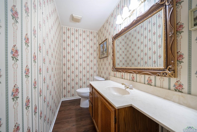 bathroom featuring vanity, hardwood / wood-style flooring, and toilet