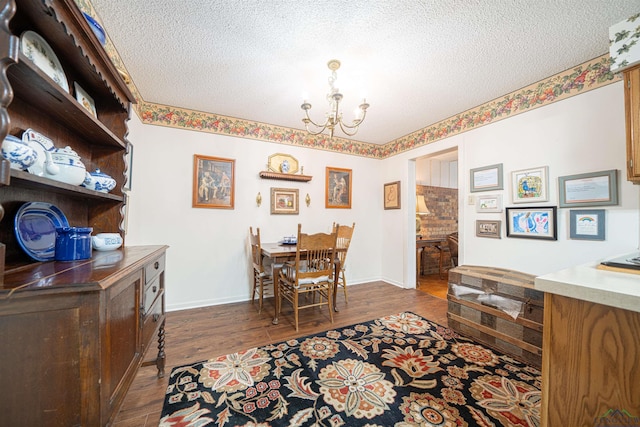 dining room with a textured ceiling, dark hardwood / wood-style floors, and a notable chandelier