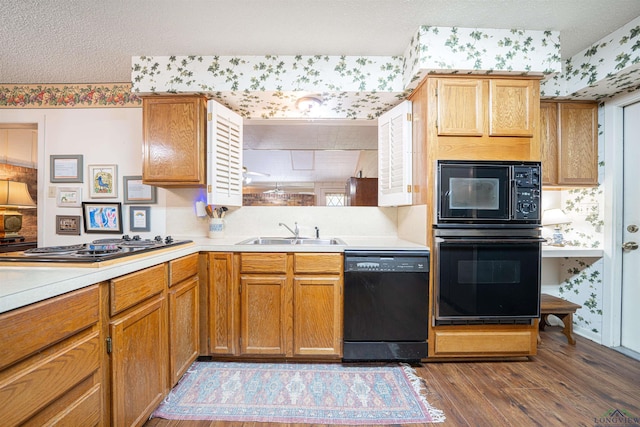 kitchen with a textured ceiling, sink, dark hardwood / wood-style floors, and black appliances