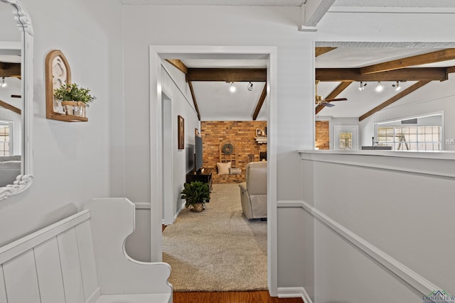 hallway with carpet floors and lofted ceiling with beams