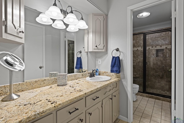 bathroom with tile patterned floors, ornamental molding, vanity, toilet, and a shower with shower door