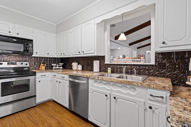 kitchen featuring white cabinets, decorative backsplash, hanging light fixtures, and appliances with stainless steel finishes