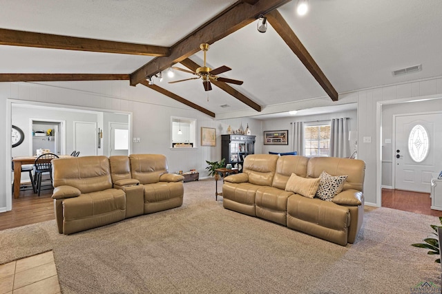 living room featuring ceiling fan, lofted ceiling with beams, carpet floors, and a textured ceiling