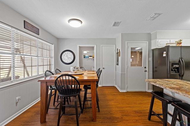 dining area with a textured ceiling and hardwood / wood-style flooring