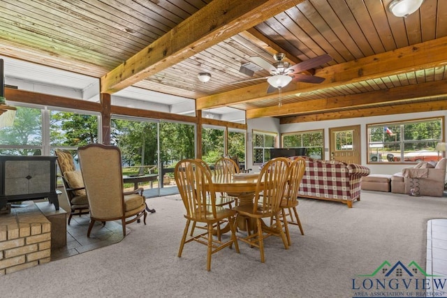 620 Shadywood Ln, Avinger, TX 75630 - dining area featuring carpet floors, a wood stove, beamed ceiling, and a ceiling fan