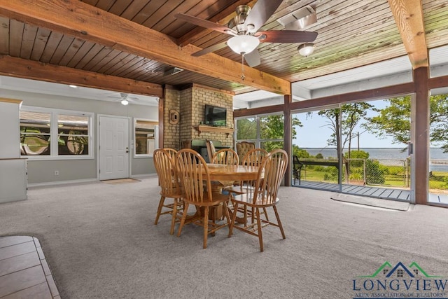 620 Shadywood Ln, Avinger, TX 75630 - dining space with a ceiling fan, carpet flooring, a wood ceiling with exposed beams, and a fireplace