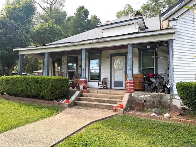 123 E 12th St, Mount Pleasant, TX 75455 - view of front of house with a porch, a front yard, and roof with shingles