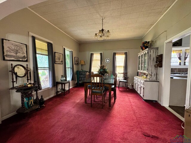 123 E 12th St, Mount Pleasant, TX 75455 - dining area with ornamental molding, a chandelier, dark carpet, and baseboards