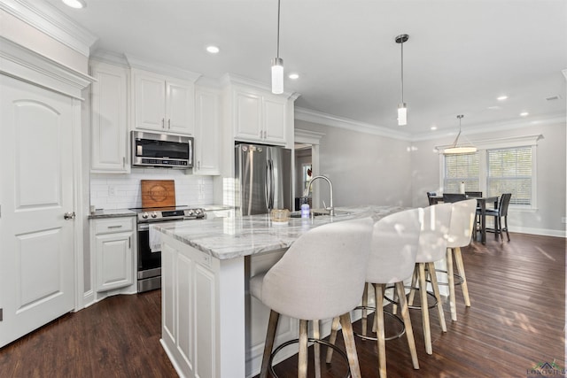 kitchen with white cabinets, a large island, pendant lighting, and stainless steel appliances