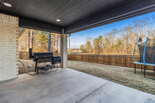 view of patio featuring a trampoline and area for grilling