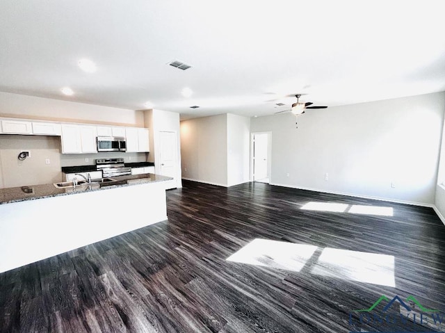 kitchen featuring sink, white cabinetry, stone countertops, dark hardwood / wood-style floors, and stainless steel appliances