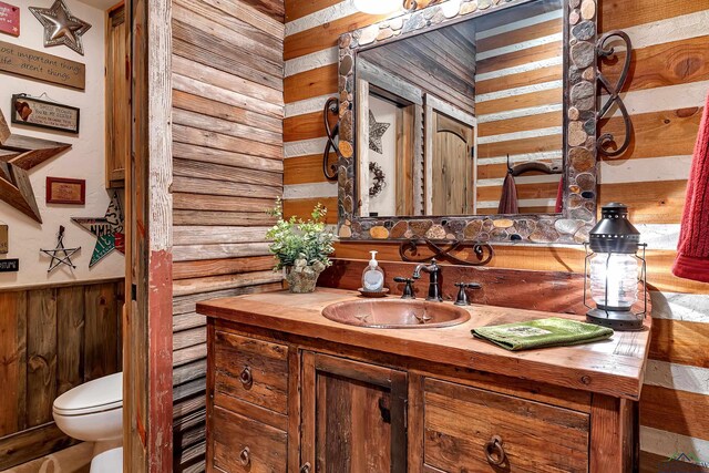 1355 Snapdragon Rd, Diana, TX 75640 - bathroom with toilet, wooden walls, and vanity