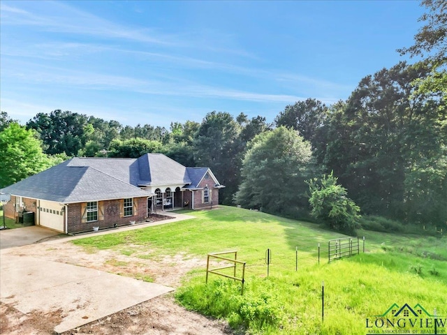 view of yard with a rural view and a garage