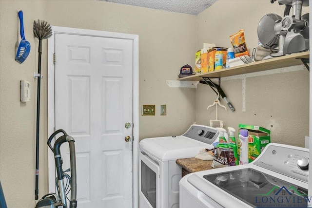 laundry room with independent washer and dryer and a textured ceiling