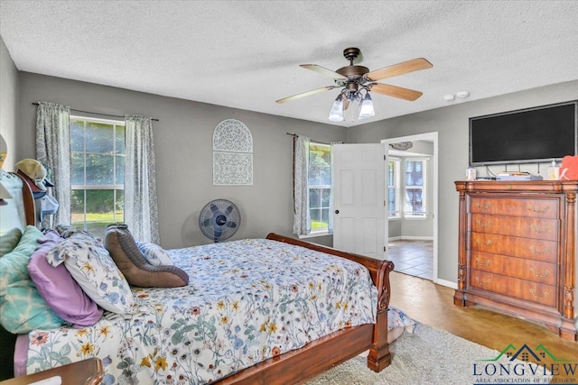 bedroom featuring ceiling fan and a textured ceiling