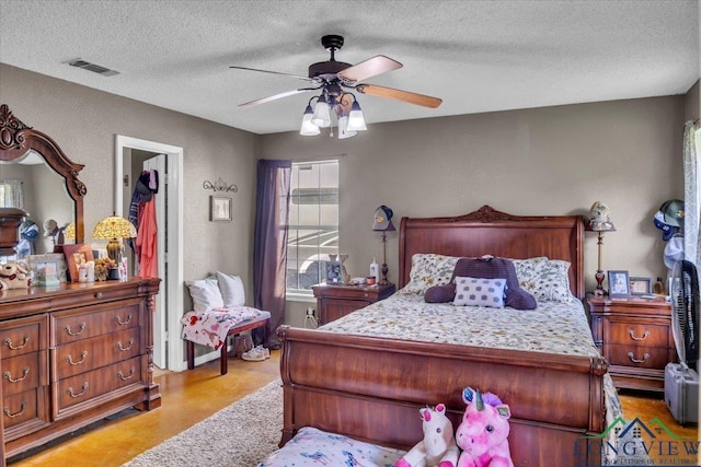 bedroom with a textured ceiling and ceiling fan