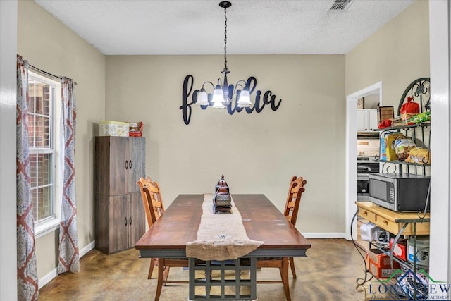 dining area with a chandelier and a textured ceiling