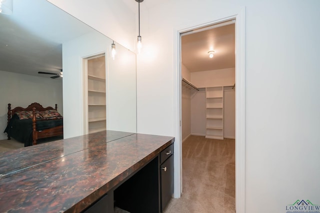 spacious closet with light carpet and ceiling fan