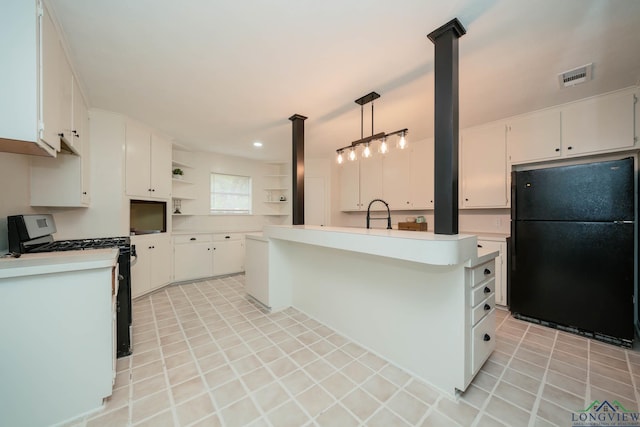 kitchen featuring white cabinets, decorative light fixtures, black fridge, and white range with gas cooktop