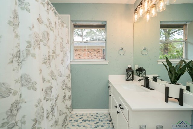 bathroom featuring vanity, a healthy amount of sunlight, and curtained shower