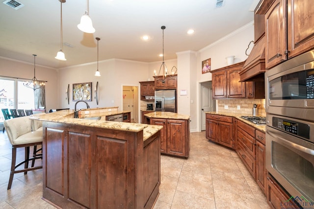 kitchen with a spacious island, decorative light fixtures, and appliances with stainless steel finishes