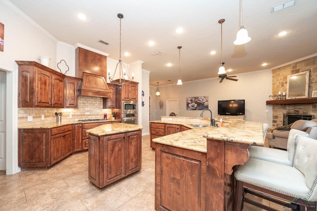 kitchen featuring decorative light fixtures, stainless steel appliances, a spacious island, open floor plan, and a sink