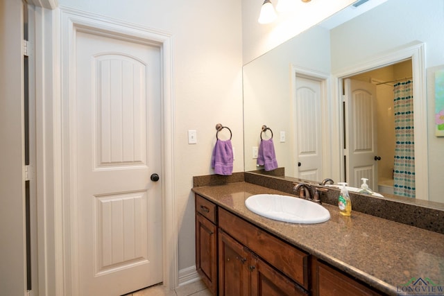 full bath with a shower with curtain, tile patterned floors, and vanity