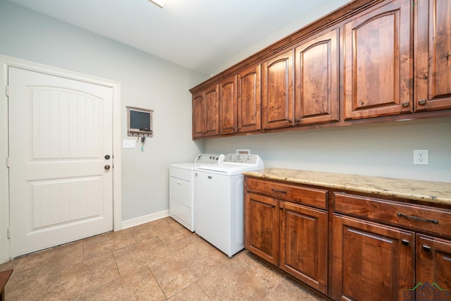 laundry room featuring cabinet space, baseboards, and washing machine and clothes dryer