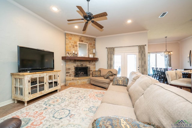 living room with baseboards, visible vents, crown molding, a fireplace, and ceiling fan with notable chandelier