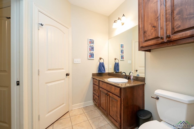 bathroom featuring tile patterned flooring, baseboards, vanity, and toilet