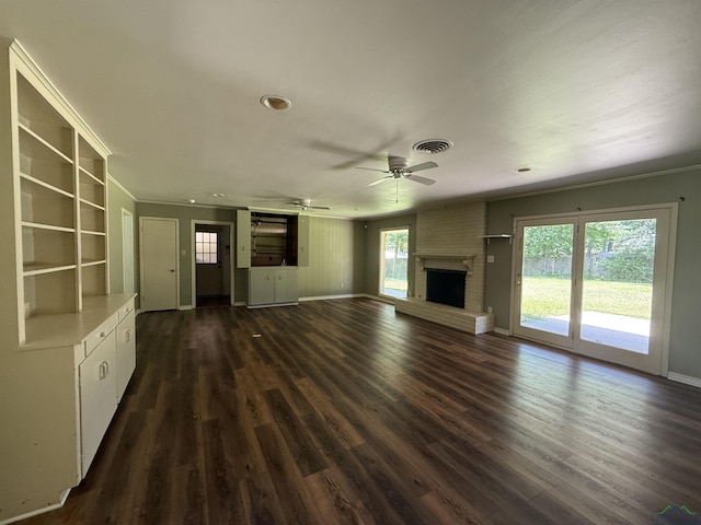 1705 Hyacinth Dr, Longview, TX 75601 - unfurnished living room featuring dark wood-type flooring, a fireplace, a ceiling fan, ornamental molding, and recessed lighting