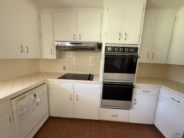 1705 Hyacinth Dr, Longview, TX 75601 - kitchen featuring multiple ovens, black electric cooktop, under cabinet range hood, white dishwasher, and backsplash