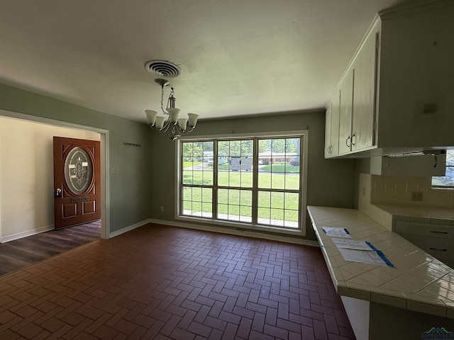 1705 Hyacinth Dr, Longview, TX 75601 - unfurnished dining area featuring a chandelier and brick patterned flooring