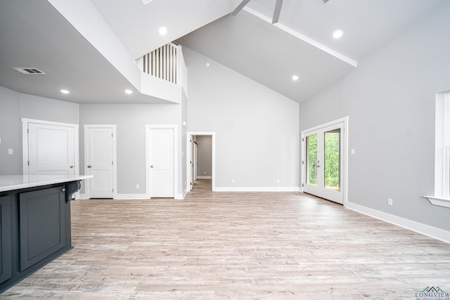 unfurnished living room featuring light hardwood / wood-style flooring and high vaulted ceiling