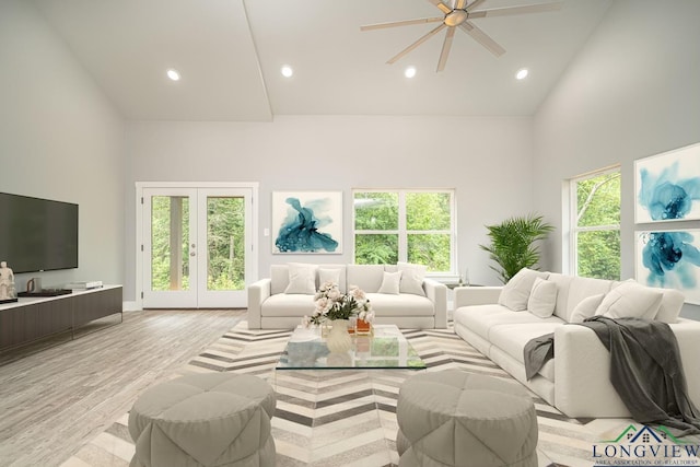 living room with ceiling fan, light wood-type flooring, and high vaulted ceiling