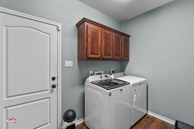 clothes washing area featuring cabinets, dark hardwood / wood-style floors, and washer and clothes dryer