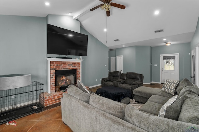 tiled living room featuring ceiling fan, lofted ceiling with beams, and a brick fireplace