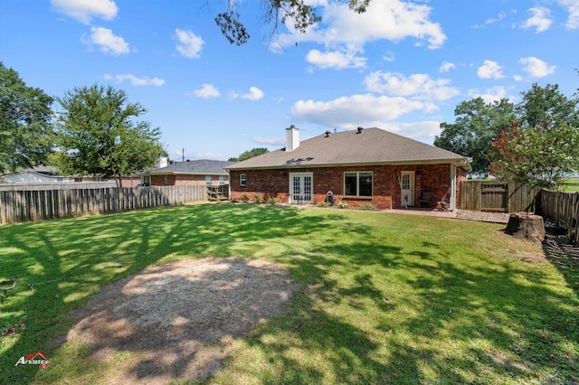 rear view of property with a lawn and a patio