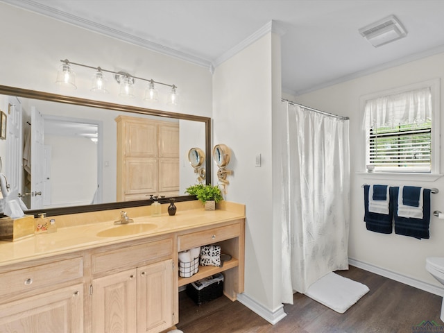 bathroom with crown molding, vanity, toilet, wood finished floors, and visible vents