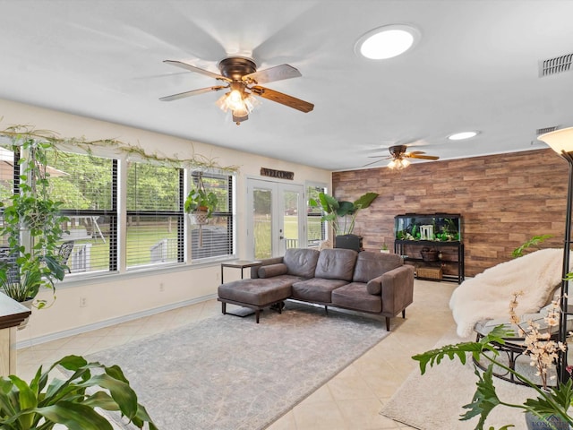 living area featuring light tile patterned floors, ceiling fan, french doors, and visible vents