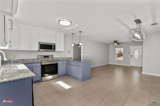 kitchen featuring stainless steel appliances, decorative light fixtures, sink, and white cabinets